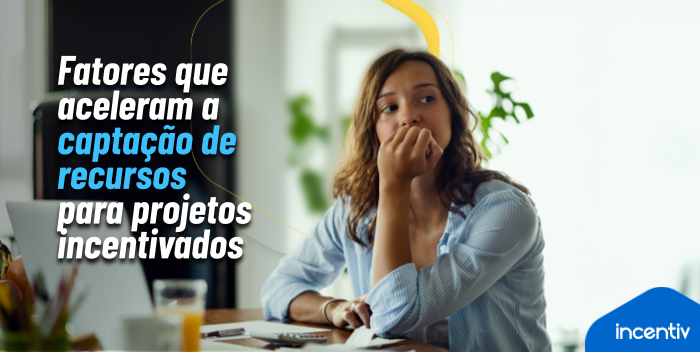 Equipe de projeto cultural comemorando captação concluída em frente a painel digital de indicadores